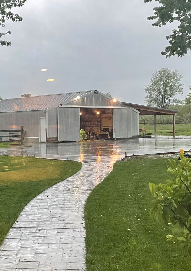 Barn driveway installation with stamped concrete walkway