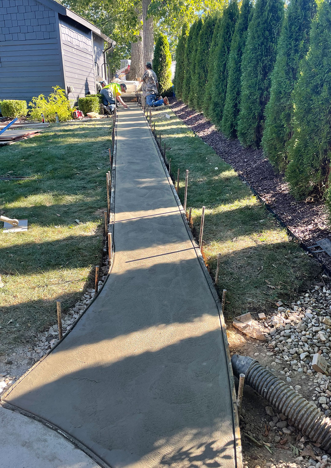 Concrete sidewalk pathway around house installation